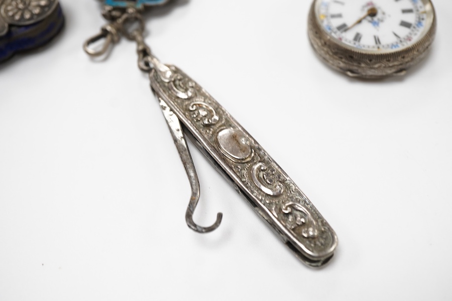 An enamel chatelaine, late 19th/early 20th century, composed of metal plaques applied with foliate patterns in blue, black and red enamel, indistinctly stamped maker's marks, suspending a silver pin cushion and a silver